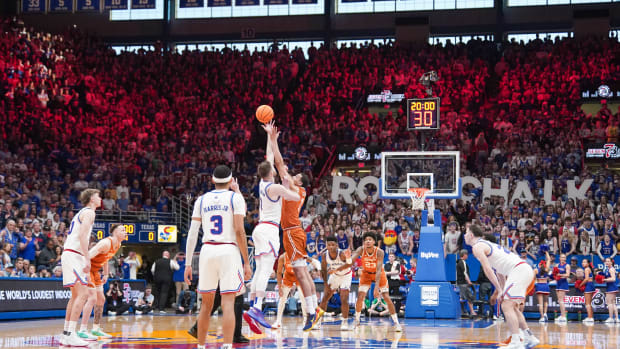 Feb 24, 2024; Lawrence, Kansas, USA; Kansas Jayhawks center Hunter Dickinson (1) and Texas Longhorns forward Dylan Disu (1) fight for the opening jump ball during the first half at Allen Fieldhouse.
